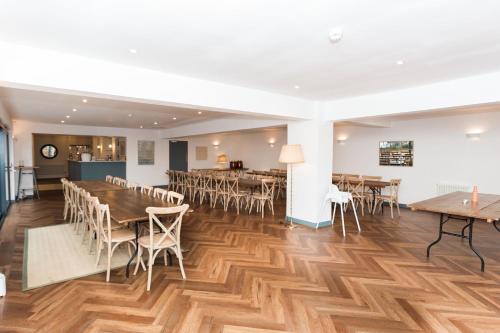 a dining room with wooden floors and tables and chairs at Torr House Hotel in Dumfries