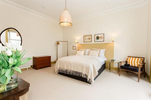 a bedroom with a bed and a chair and a mirror at Torr House Hotel in Dumfries