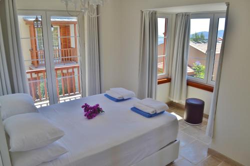 Un dormitorio con una cama blanca con flores púrpuras. en Villa Zeytin Kalkan, en Kas