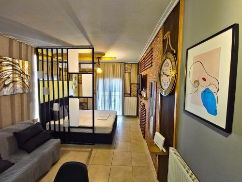 a living room with a couch and a clock on a wall at GpxClrTheStreetFashionSuiteNW in Larisa
