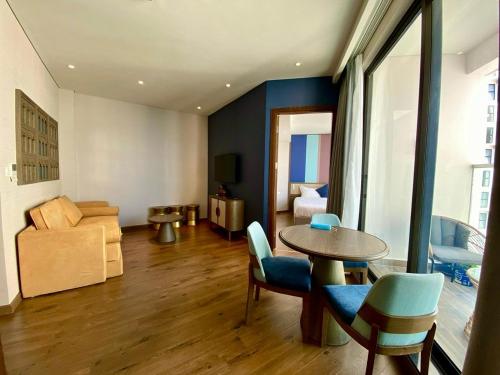 un salon avec une table, des chaises et un canapé dans l'établissement Apec-Mandala - Condotel - Ocean view-ADP TOUR, à Ấp Thiẹn Ái
