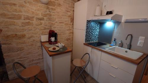 une petite cuisine avec un évier et un comptoir dans l'établissement Le Clos des Perrières, à Dijon