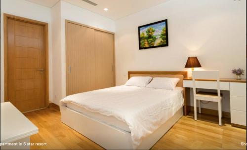 a bedroom with a bed and a desk and a door at Ocean Apartment in Danang