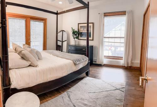 a bedroom with a bed and a dresser and windows at Hidden Haven in Traverse City