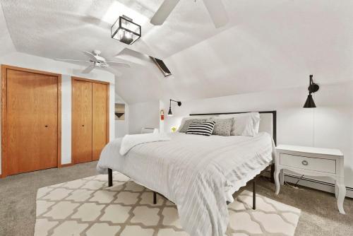 a white bedroom with a bed and a ceiling fan at Hidden Haven in Traverse City