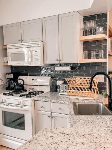 a kitchen with white cabinets and a sink at Hidden Haven in Traverse City