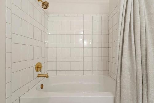 a white tiled bathroom with a tub and a shower at Hidden Haven in Traverse City