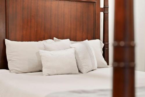 a bed with white pillows and a wooden headboard at Hidden Haven in Traverse City