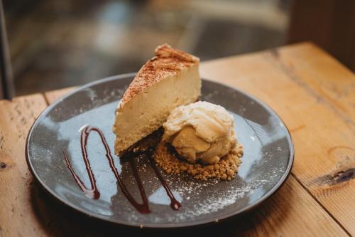 a piece of cake and ice cream on a plate at The White Lion Inn in Whissendine