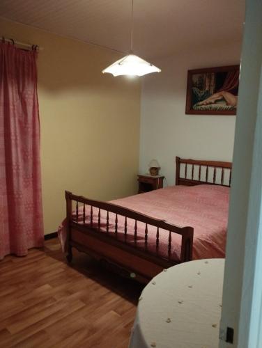 une chambre avec un lit, une table et une lampe dans l'établissement Gite Saint-Victor-et-Melvieu, à Viala-du-Tarn