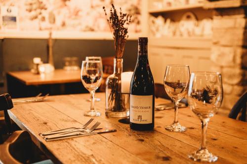 a bottle of wine sitting on a wooden table with wine glasses at The White Lion Inn in Whissendine