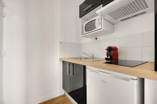 une cuisine avec un comptoir et un appareil rouge dans l'établissement L'Exotique Urbain - Studio Cosy - Métro & Gare, à Toulouse