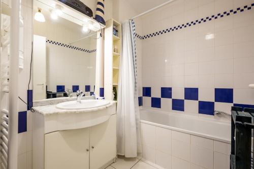 La salle de bains bleue et blanche est pourvue d'un lavabo et d'une baignoire. dans l'établissement Le Nid du Betey T3, 2CHB, 400m de la plage, à Andernos-les-Bains