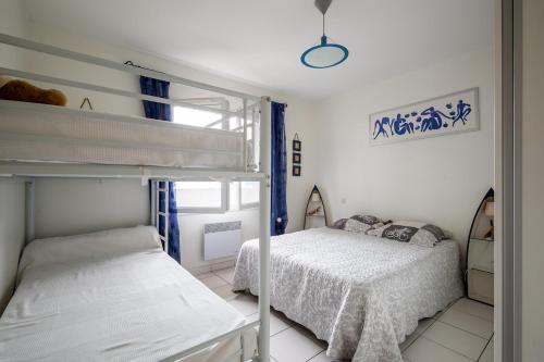 une chambre avec deux lits superposés et une fenêtre dans l'établissement Le Nid du Betey T3, 2CHB, 400m de la plage, à Andernos-les-Bains