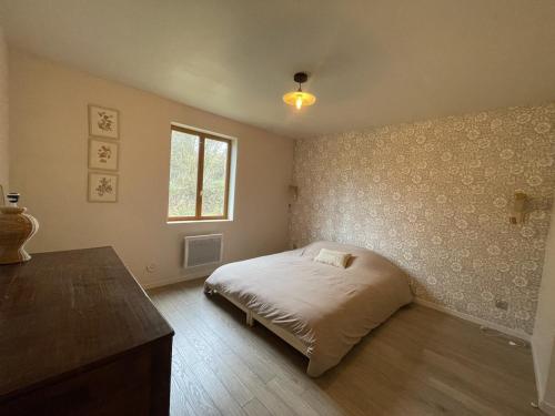 a bedroom with a bed and a window at Ma Dâme Alma in Oulches-la-Vallée-Foulon