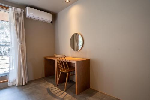 a room with a desk and a mirror and a window at HARUKA KANATA 森のヴィラ in Minamiboso