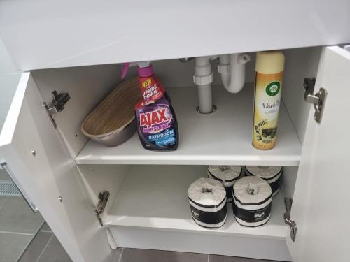 a kitchen cabinet with food items on the shelf at Modern Studio 10mins walk to Wollongong Hospital & Train Station with Parking in Wollongong