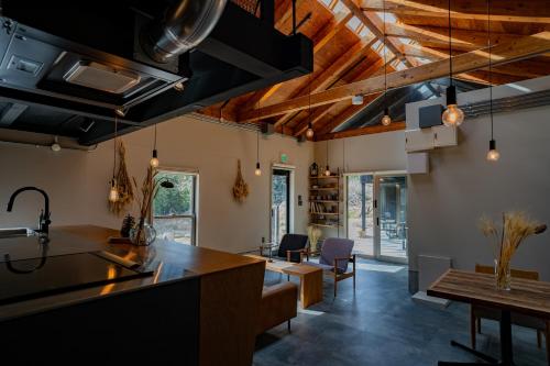 a kitchen and living room with wooden ceilings at HARUKA KANATA 森のヴィラ in Minamiboso