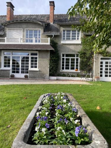 a house with a bed of flowers in front of a yard at Les Hortensias in Espoey