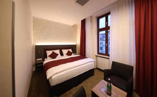 a hotel room with a bed and a window at Hotel Golden Pearl Magdeburg im Stadtzentrum in Magdeburg