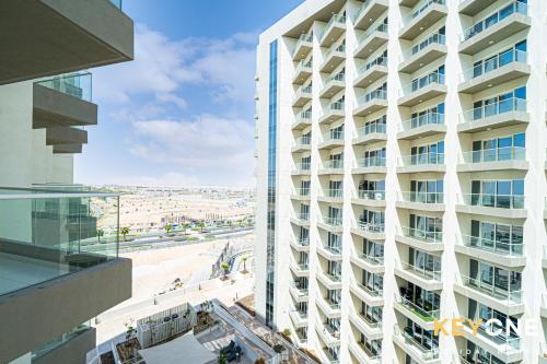 un edificio blanco alto con vistas a la playa en Viridis Residence Cozy Studio Living, en Dubái