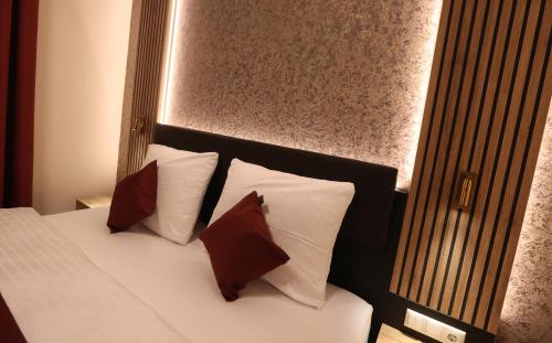 a bedroom with a bed with pillows and a headboard at Hotel Golden Pearl Magdeburg im Stadtzentrum in Magdeburg