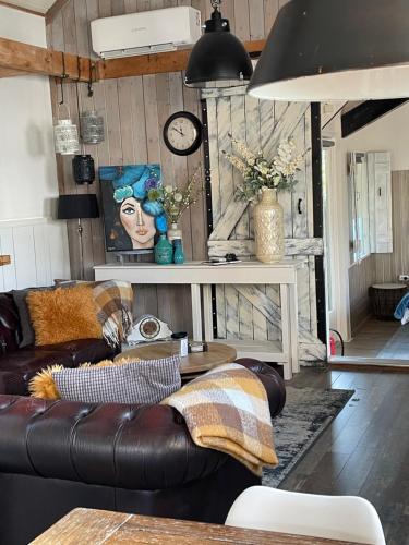 a living room with a leather couch and a table at Sandra’s Gastenverblijf in Oostvoorne