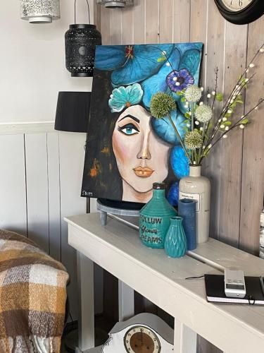 a painting of a woman with flowers on a table at Sandra’s Gastenverblijf in Oostvoorne