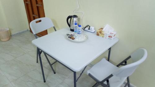 a white table with two chairs and bottles on it at SALEM House Hostel Nizwa in Nizwa