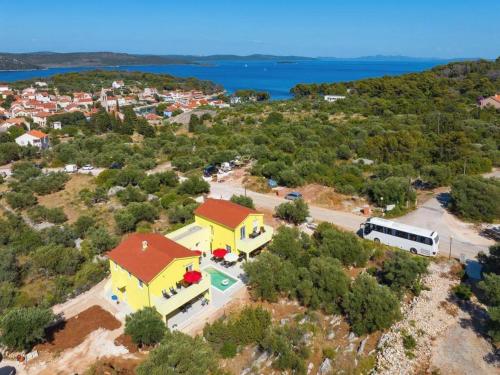 an aerial view of a yellow house with a pool at Villa Gaby with Heated Pool in Božava