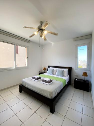 a bedroom with a bed and a ceiling fan at STAY Anthea Gardens - Calm Living in Paphos
