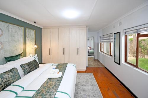 a bedroom with a large white bed in a room at Poolside cottage in Germiston