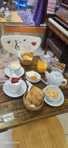 a table with plates of food and a piano at Hotel Juramento in Buenos Aires