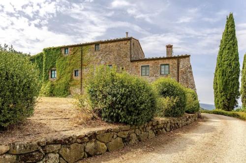 an old stone house with ivy on the side of a road at Villa Il Poggio in Greve in Chianti