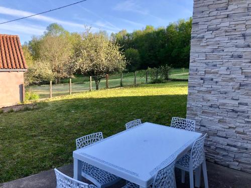 une table blanche et des chaises sur une terrasse dans l'établissement Maison dans hameau calme et proche tous commerces, à Saint-Front-la-Rivière