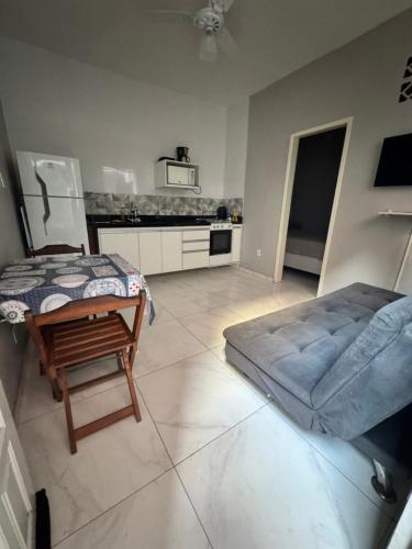 - un salon avec un lit et une chaise dans l'établissement Hospedagem dos Massa- Casas no Centro de Arraial- Faça tudo a Pé!, à Arraial do Cabo