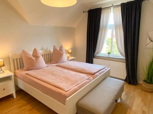 a bedroom with a bed with white pillows and a window at Gröpernblick - Zentrumsnahe FeWo I 2 Schlafzimmer I 100 qm I Parkplätze in der Umgebung in Quedlinburg