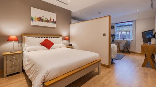 a bedroom with a bed and a desk and a television at Barbican Serviced Apartments by LovelyStay in London