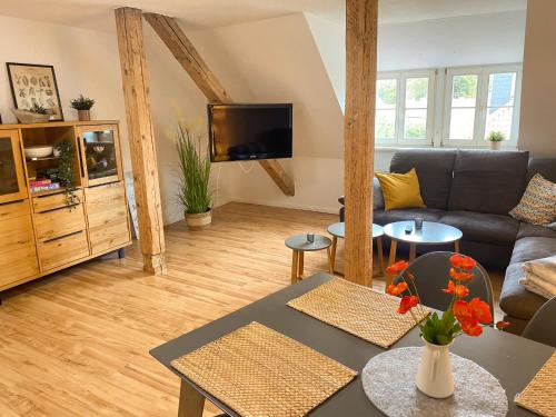 a living room with a couch and a tv at Gröpernblick - Zentrumsnahe FeWo I 2 Schlafzimmer I 100 qm I Parkplätze in der Umgebung in Quedlinburg