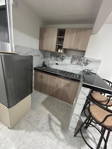 a kitchen with wooden cabinets and a black counter top at SDI Ibagué in Vallecito
