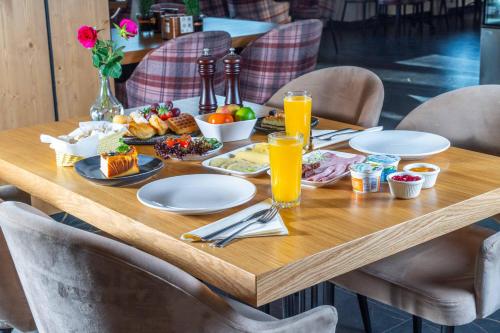 a wooden table with food and drinks on it at Hotel Maria & Spa in Szczawnica