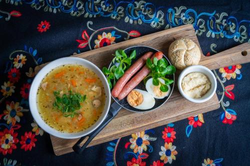 a tray with a bowl of soup and a plate of food at Hotel Maria & Spa in Szczawnica