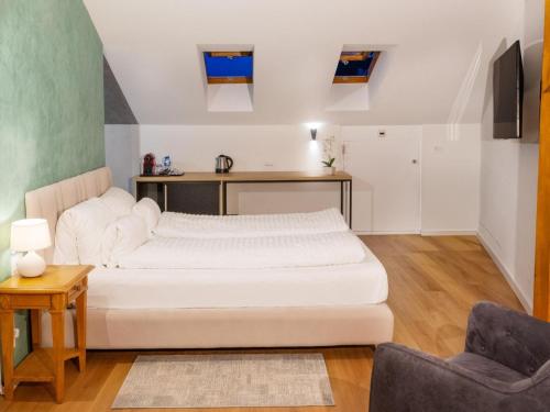 a bedroom with a white bed and a chair at Boutique Hotel OchSen Self-Check-In in Bad Ragaz
