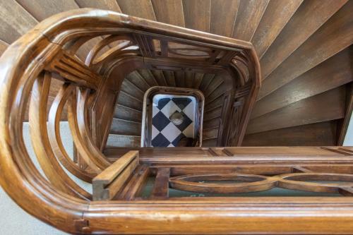 a wooden spiral staircase with a mirror in a room at Kasteel Pietersheim Maastricht - Lanaken in Lanaken