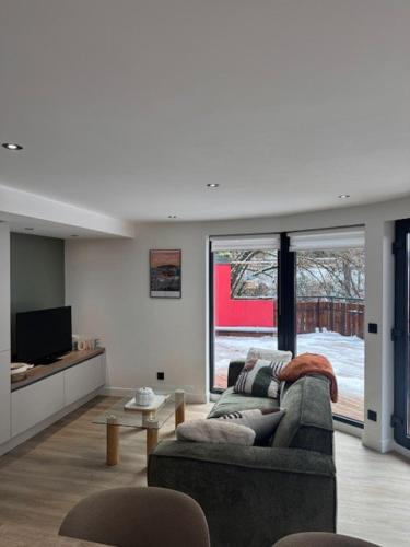 un salon avec un canapé et une télévision dans l'établissement Nouveau T3 RDC 100m du parc, à Brides-les-Bains