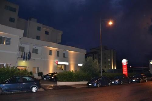 a group of cars parked in front of a building at night at Hotel Palace Gioia Tauro in Gioia Tauro