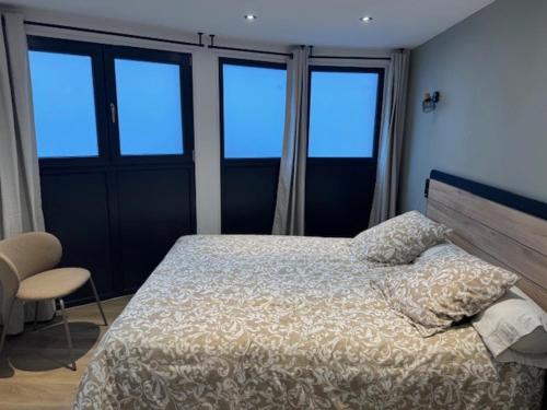 - une chambre avec un lit et quelques fenêtres dans l'établissement Nouveau T3 RDC 100m du parc, à Brides-les-Bains