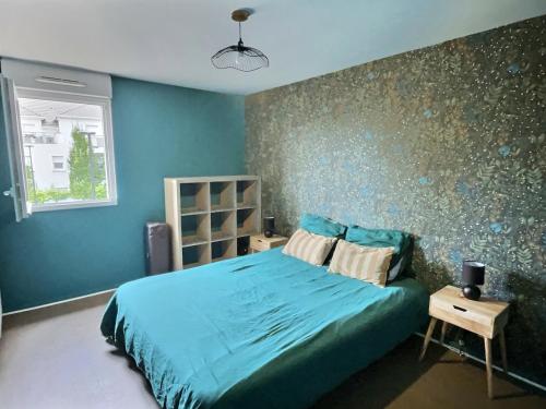 une chambre avec un lit avec un mur bleu dans l'établissement Confort Exotique Idéal Pour Les Familles Et Les Groupes, à Persan