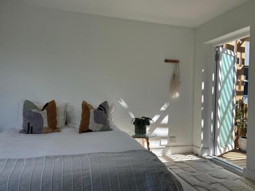 a bedroom with a bed with pillows on it at Sunset Studios Surf & Ocean view in Cape Town