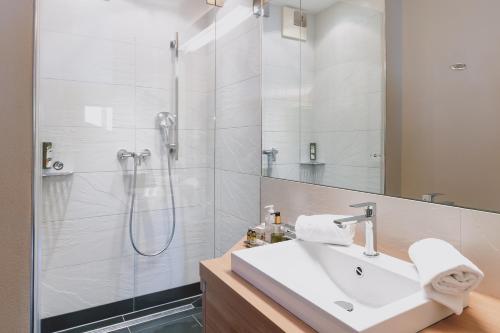 a bathroom with a sink and a shower at Auhof Wirtshaus & Suiten in Kaprun